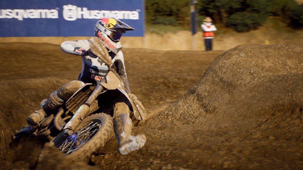 Pilota di motocross in azione su un tracciato di terra, mentre affronta una curva