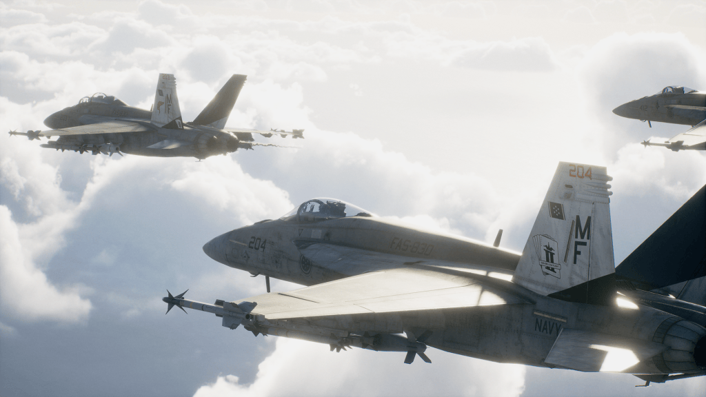 Tre aerei militari F/A-18 in volo tra le nuvole.