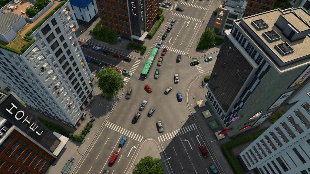 Vista aerea di un incrocio trafficoso con edifici alti e veicoli in movimento.